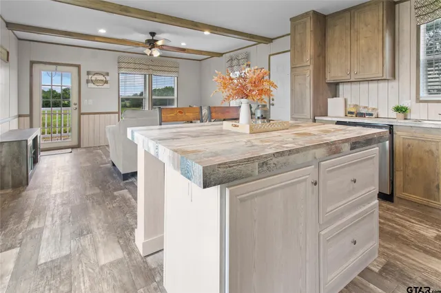 a kitchen with stainless steel appliances kitchen island granite countertop a sink and cabinets