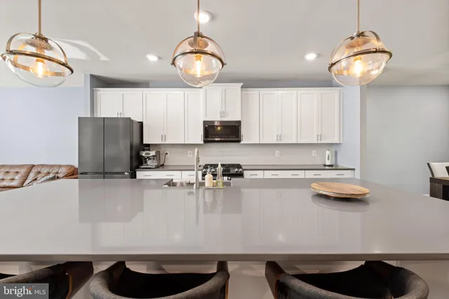 a kitchen with stainless steel appliances granite countertop a sink refrigerator stove and microwave