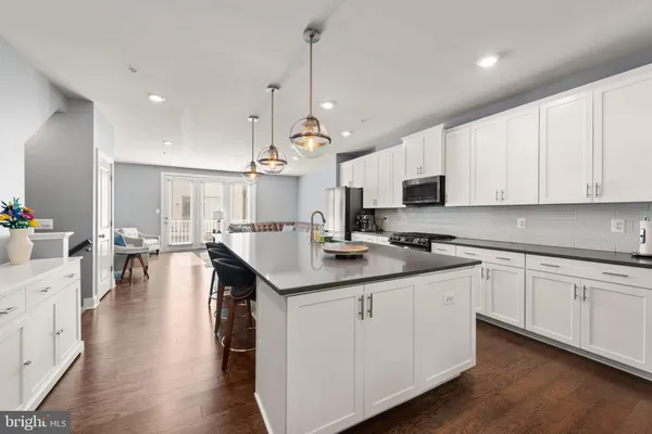 a kitchen with stainless steel appliances kitchen island granite countertop a sink a stove and cabinets