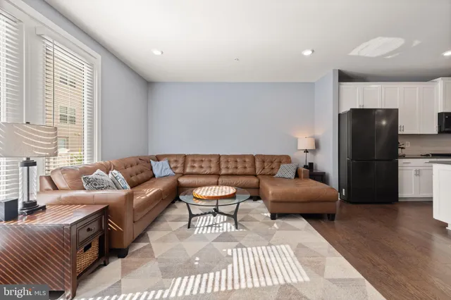 a living room with furniture a refrigerator and a table
