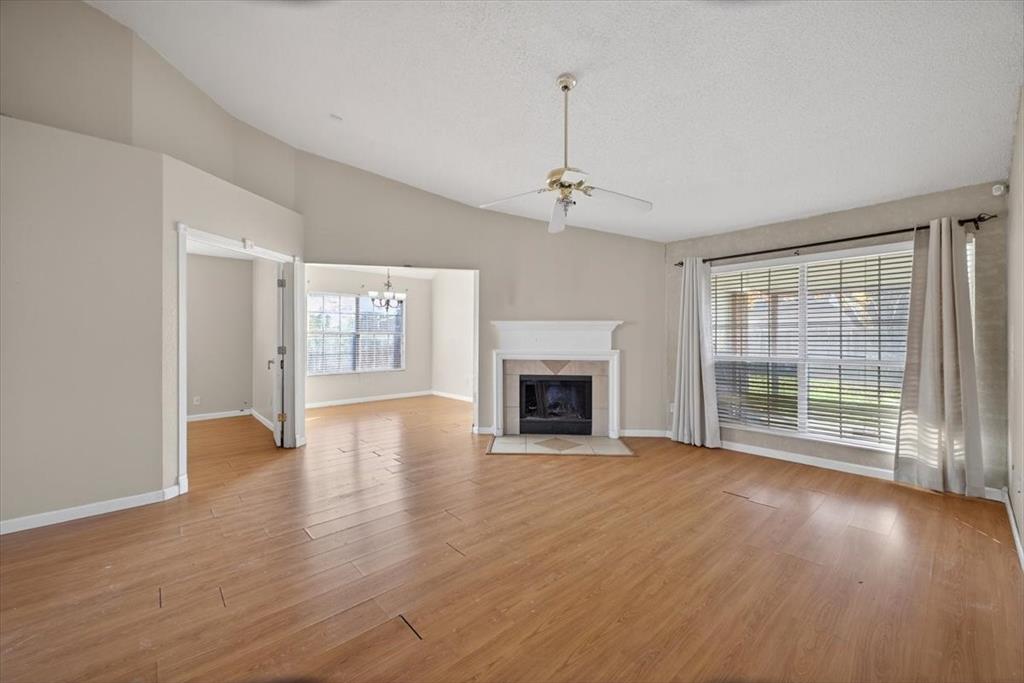 920 Danforth Place Arlington, TX 76017 - Photo 7 of 28 a view of an empty room with wooden floor fireplace and a window