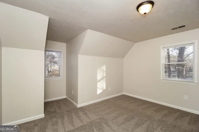 an empty room with windows and closet