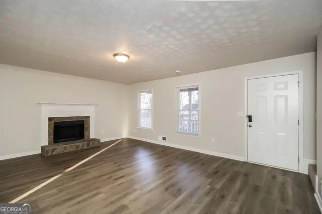 wooden floor fireplace and windows in an empty room