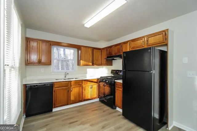 a kitchen with stainless steel appliances granite countertop a refrigerator a sink a stove and island