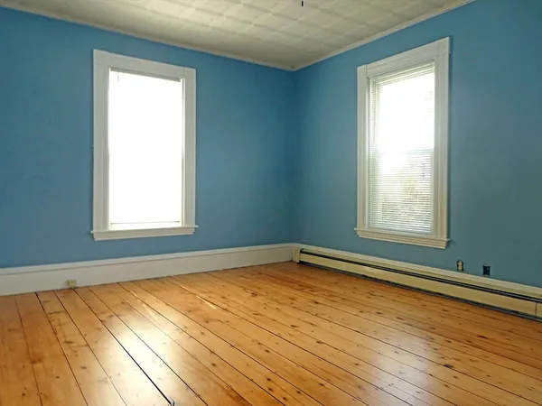 a view of a room with wooden floor and windows