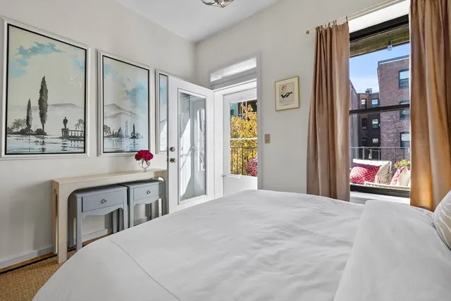 a very nice looking bedroom with a large window and a chandelier