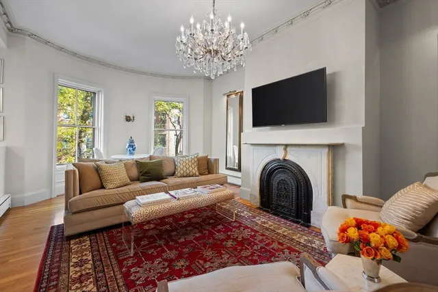 a living room with furniture a flat screen tv and a fireplace