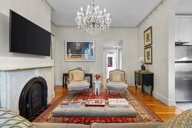 a living room with furniture a flat screen tv and kitchen view