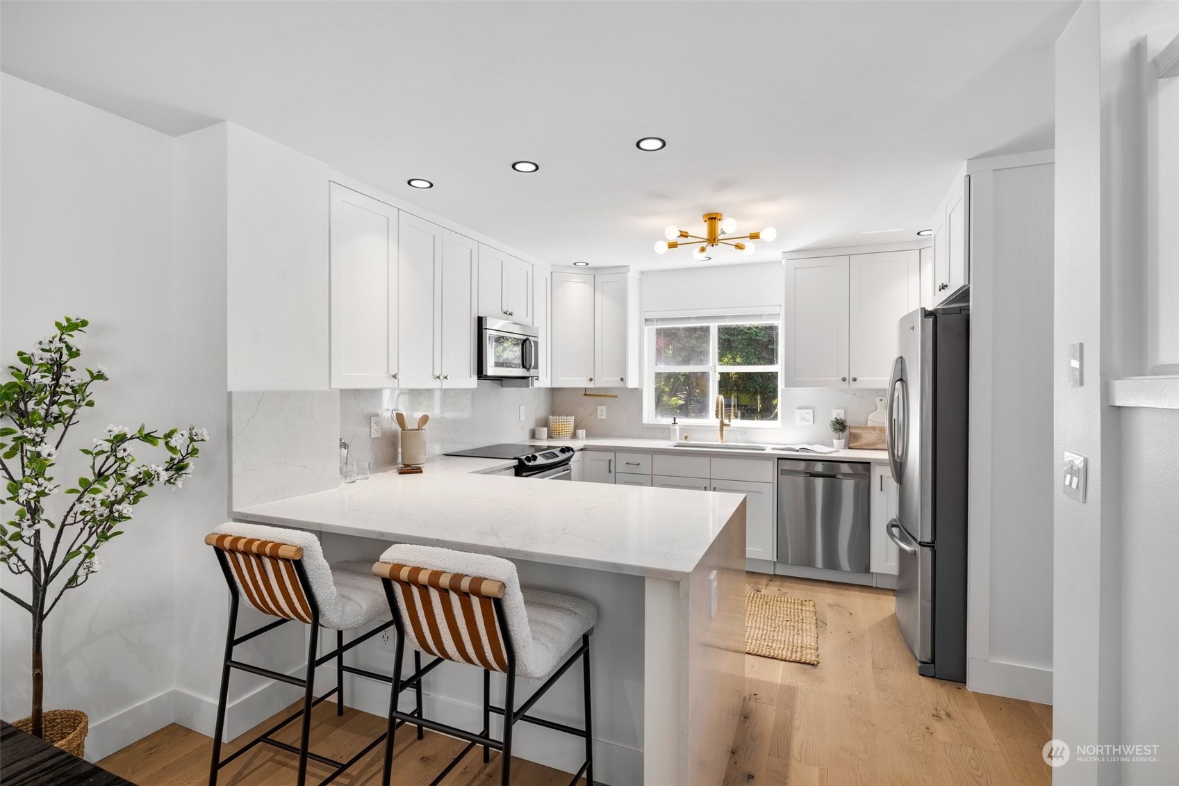 3613 22nd Avenue West, Unit B Seattle, WA 98199 - Photo 12 of 35 a kitchen with granite countertop white cabinets and stainless steel appliances