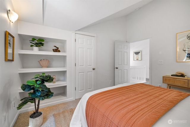 a bedroom with a bed and a potted plant