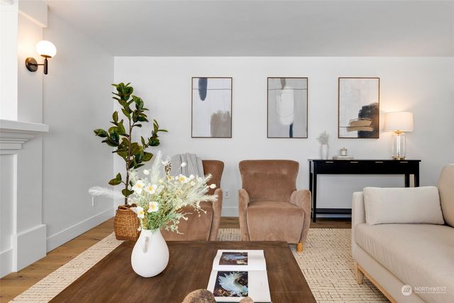a living room with furniture potted plant and wooden floor