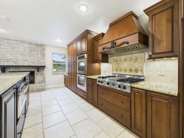 a kitchen with stainless steel appliances granite countertop a stove a sink and a refrigerator