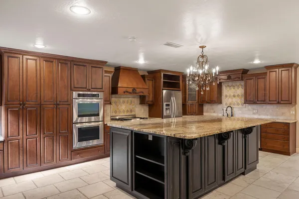 a kitchen with kitchen island granite countertop stainless steel appliances a sink stove and refrigerator