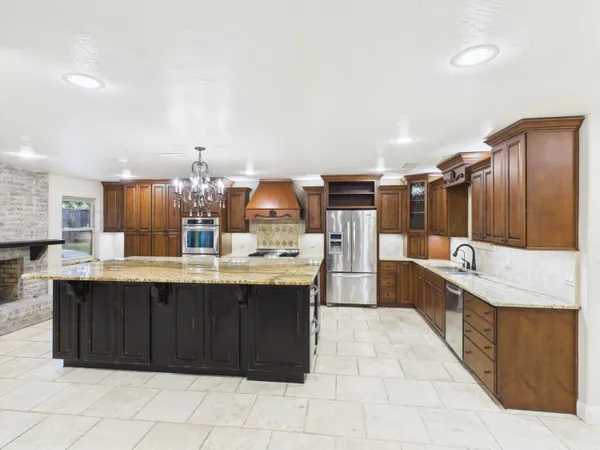 a large kitchen with kitchen island a sink stainless steel appliances and cabinets