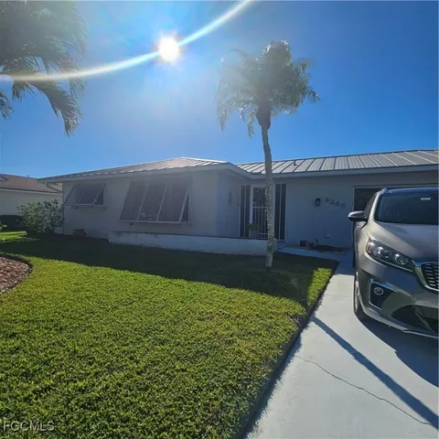 a kitchen with a table chairs microwave and cabinets