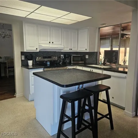 a kitchen with cabinets appliances a sink and a counter top space