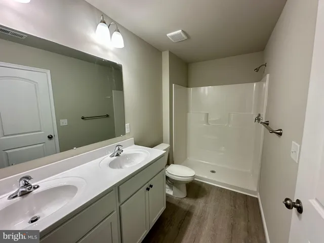 a bathroom with a double vanity sink toilet and shower