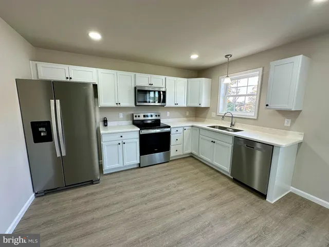 a kitchen with stainless steel appliances granite countertop a refrigerator sink and microwave