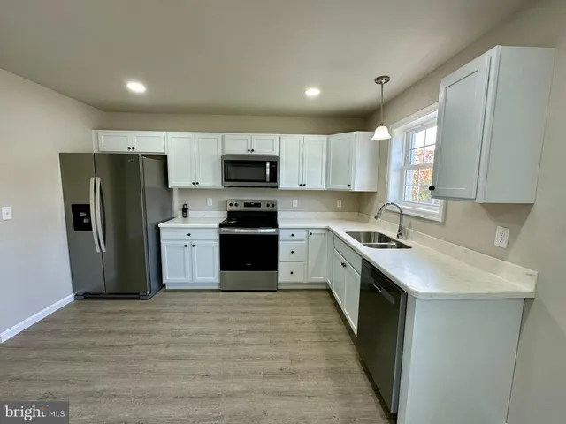 a kitchen with stainless steel appliances a refrigerator stove microwave and sink