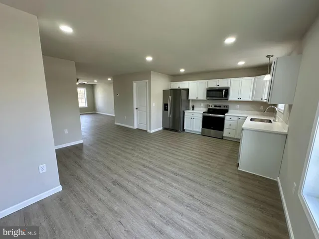 a view of kitchen with microwave refrigerator and cabinets