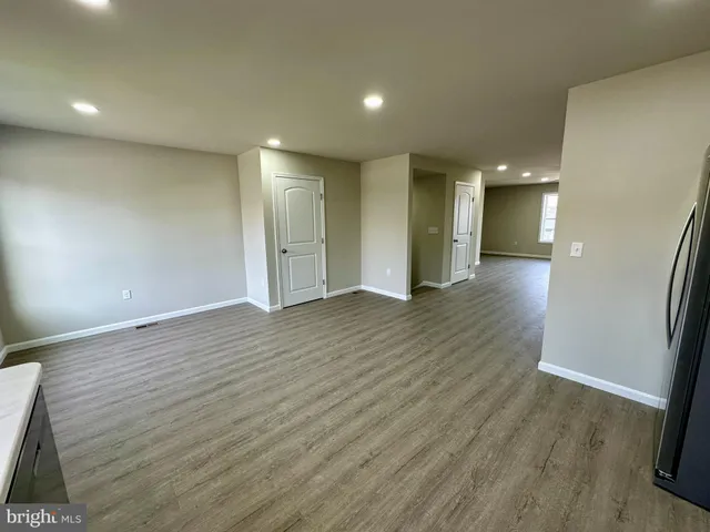 an empty room with wooden floor and entrance