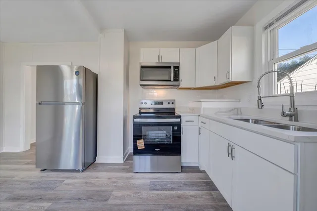 a kitchen with granite countertop a refrigerator stove and sink