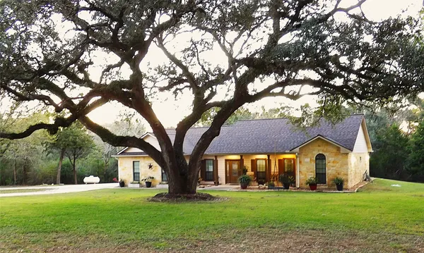 a front view of a house with a yard and trees