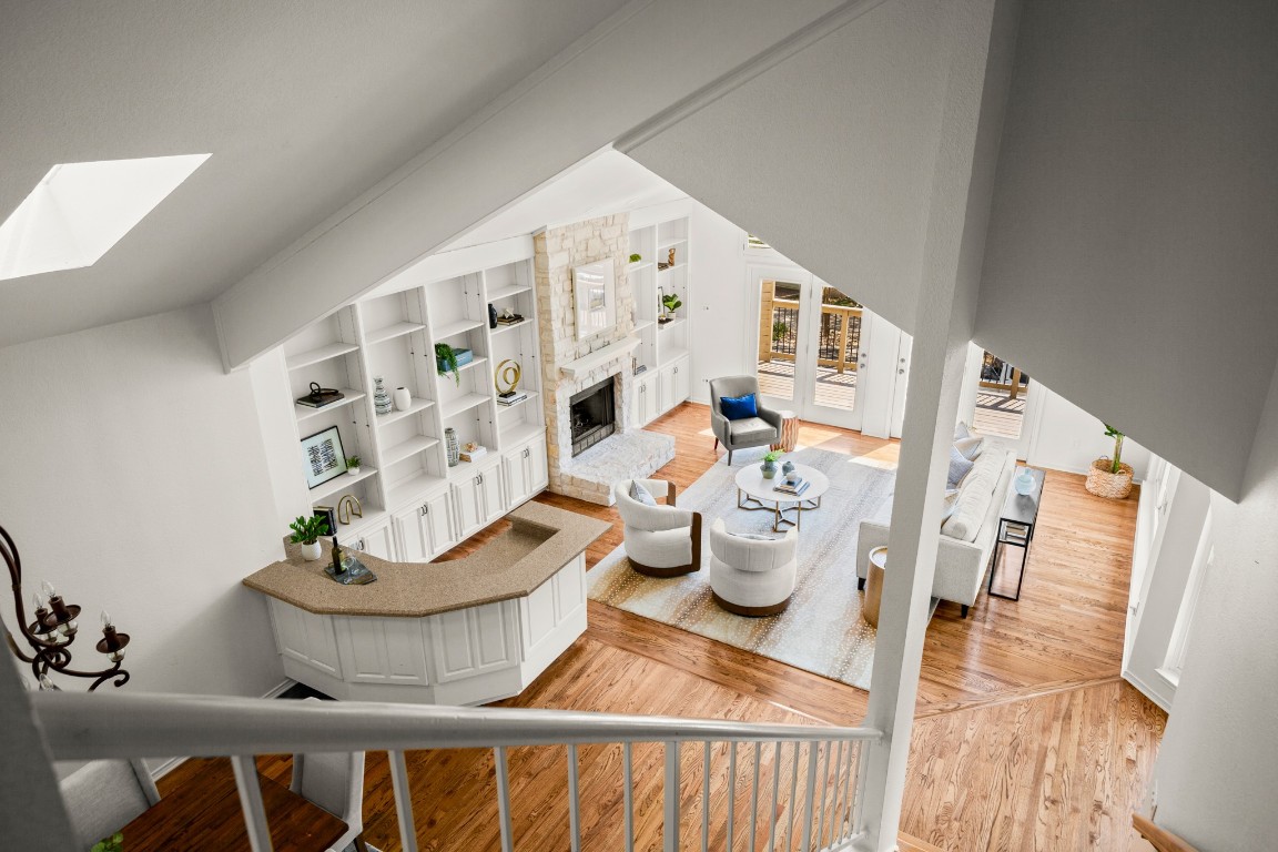 4906 Bob Cat Run Austin, TX 78731 - Photo 19 of 37 Living room with light wood-style floors, a fireplace, a skylight, and built in shelves