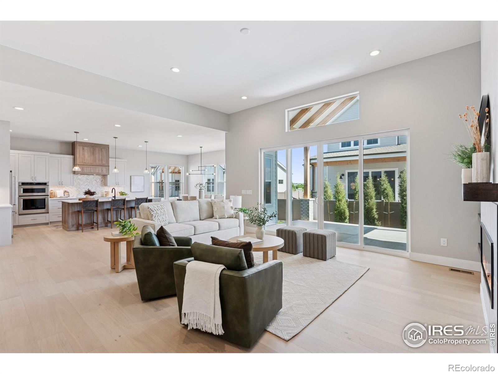 a living room with furniture window and kitchen view