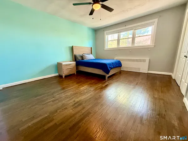 a bedroom with a bed and wooden floor