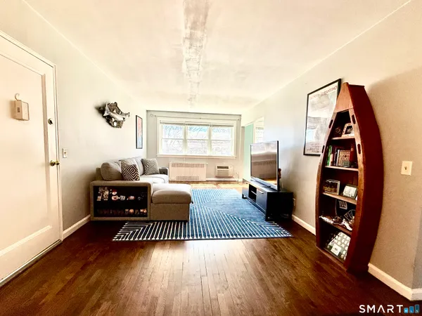a living room with furniture a flat screen tv and a large window