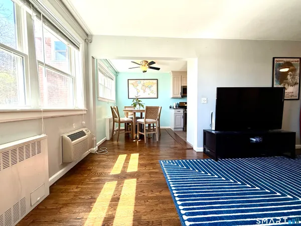 a living room with furniture a flat screen tv and a fireplace