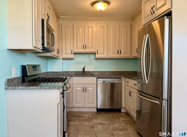 a kitchen with stainless steel appliances granite countertop a refrigerator sink and cabinets
