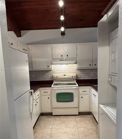a kitchen with a stove top oven and cabinets