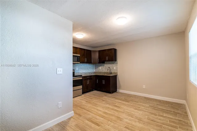 a large kitchen with a stove a refrigerator and a sink