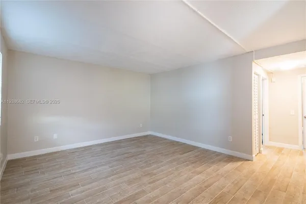 a view of an empty room with wooden floor