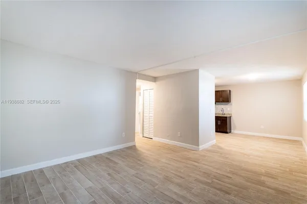 a view of an empty room with wooden floor