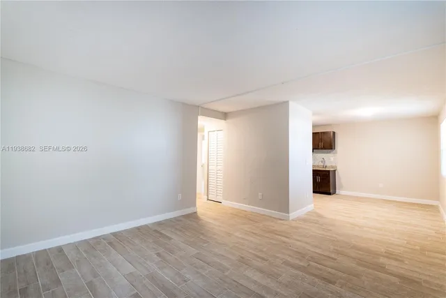 a view of an empty room with wooden floor
