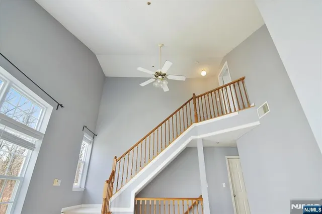 a view of staircase with railing and white walls