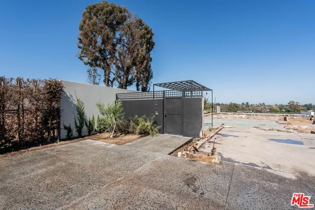 a view of a dry yard with wooden fence