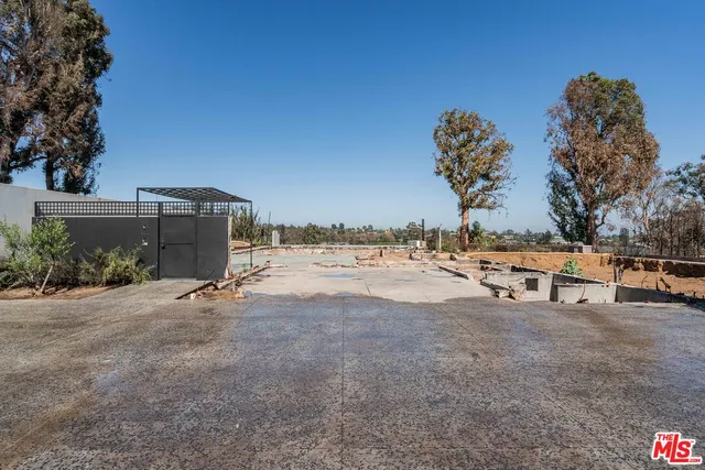 a view of dirt road with a building in the background