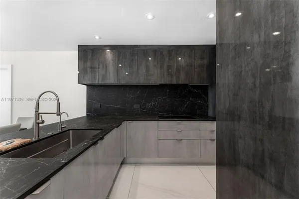a kitchen with granite countertop white cabinets and stainless steel appliances