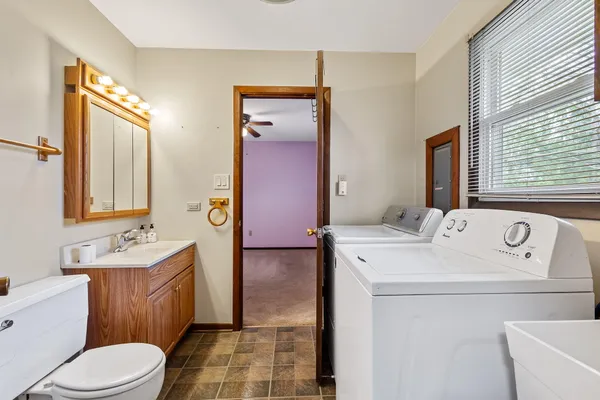 a bathroom with a sink a toilet and mirror