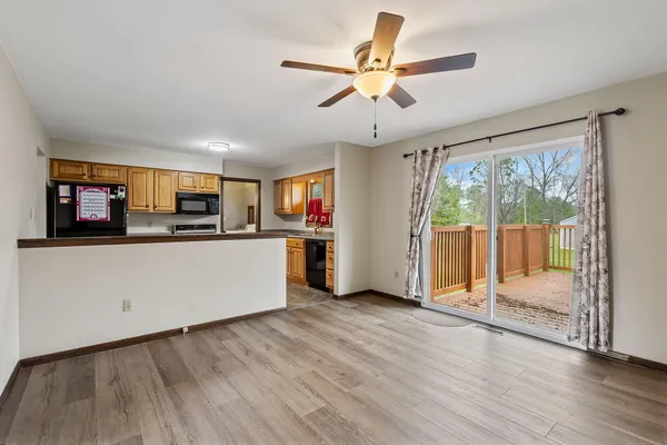 a view of a kitchen with stainless steel appliances granite countertop a stove top oven a refrigerator with wooden floor