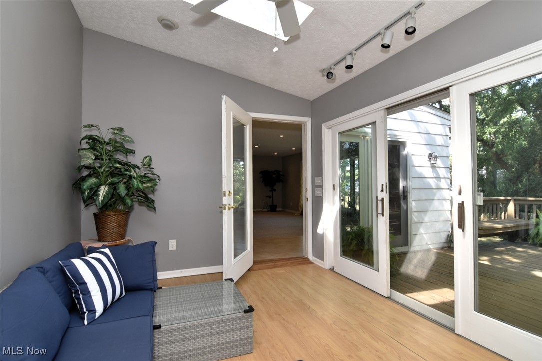 3679 Fenley Road Cleveland Heights, OH 44121 - Photo 22 of 45 Doorway with wood finished floors, french doors, a textured ceiling, a skylight, and track lighting