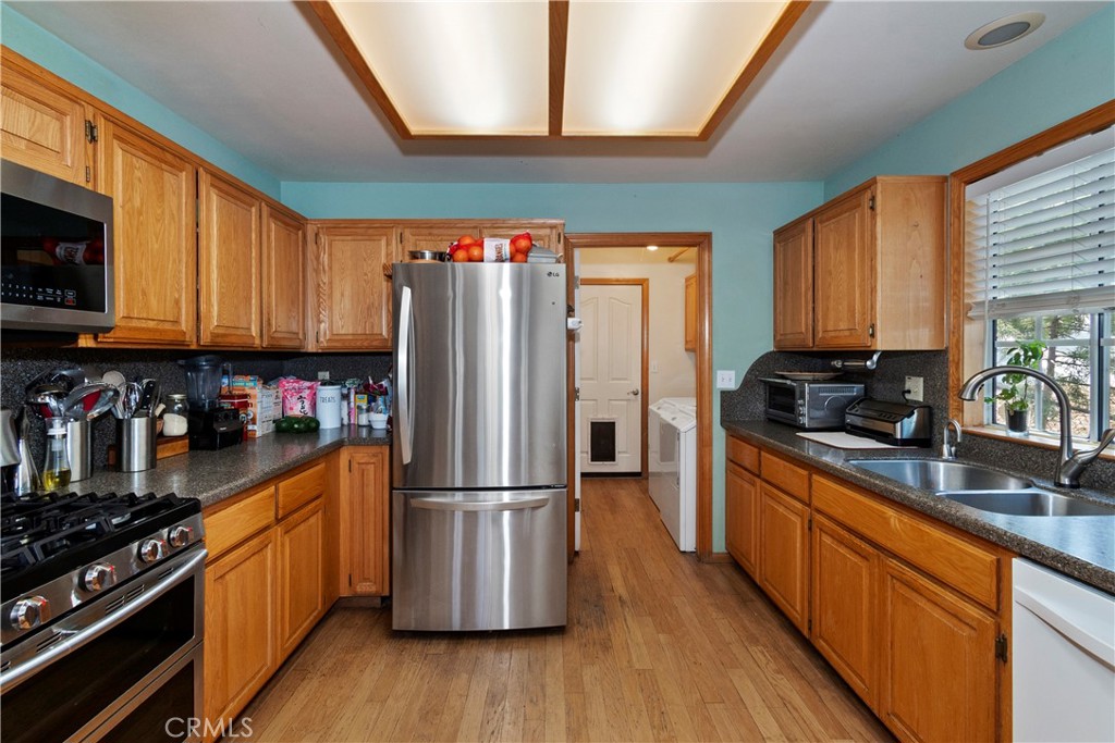28223 North Bay Road Lake Arrowhead, CA 92352 - Photo 11 of 39 a kitchen with stainless steel appliances granite countertop a refrigerator a stove top oven a sink and dishwasher with wooden floor
