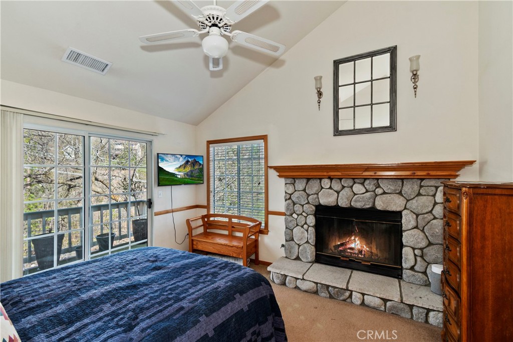 28223 North Bay Road Lake Arrowhead, CA 92352 - Photo 15 of 39 a bedroom with a bed a fireplace and windows