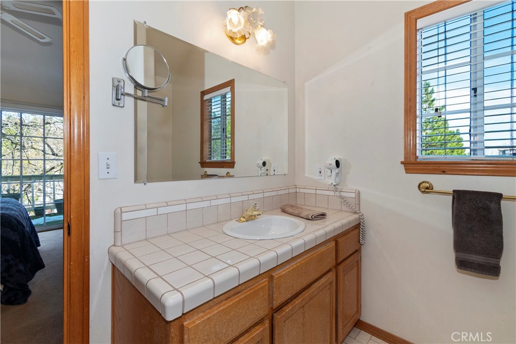 28223 North Bay Road Lake Arrowhead, CA 92352 - Photo 19 of 39 a bathroom with a sink vanity and mirror