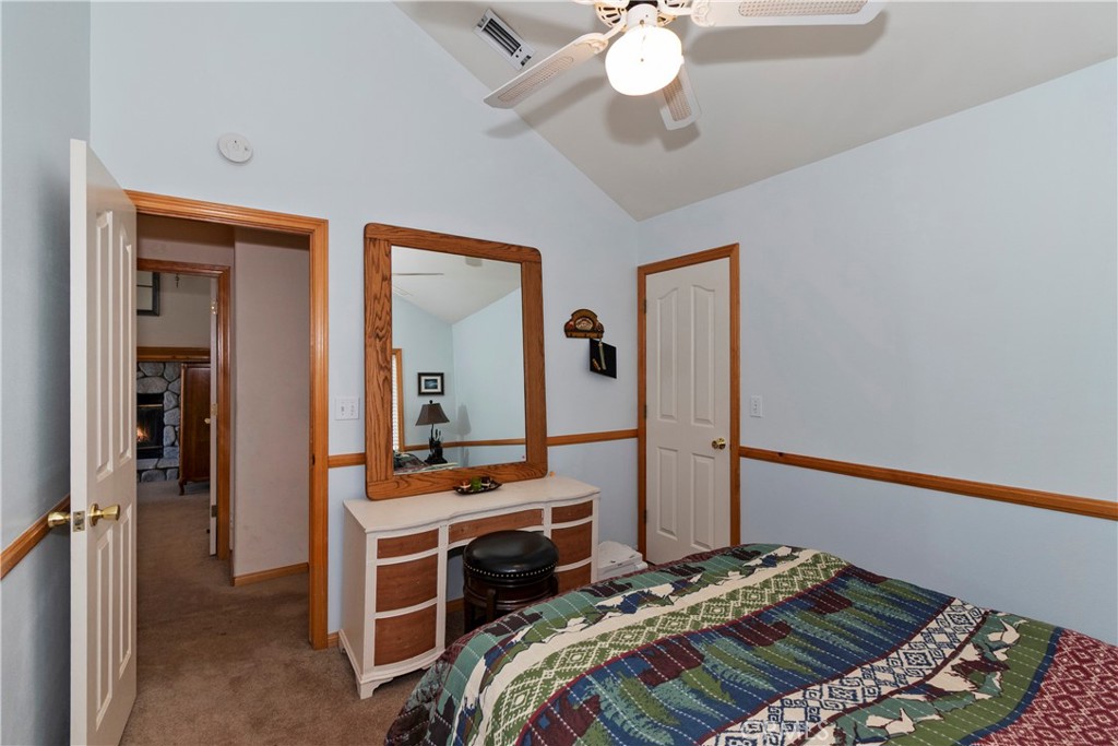 28223 North Bay Road Lake Arrowhead, CA 92352 - Photo 22 of 39 a bedroom with a bed and a chandelier