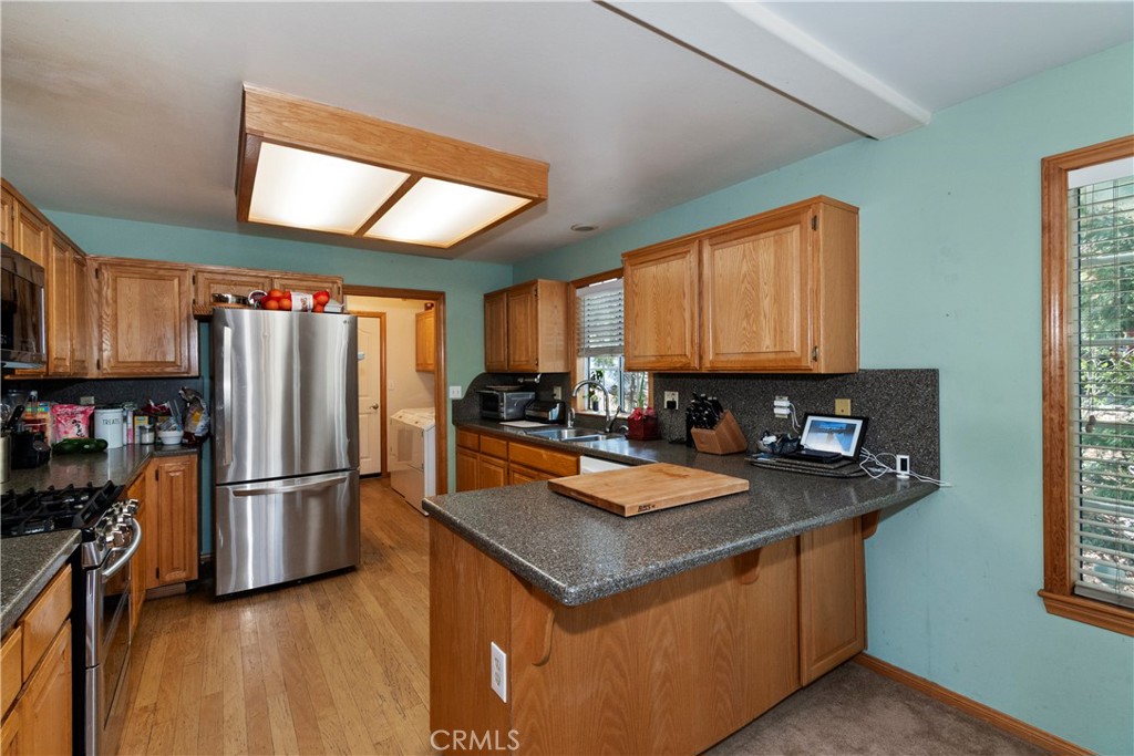 28223 North Bay Road Lake Arrowhead, CA 92352 - Photo 10 of 39 a kitchen with stainless steel appliances granite countertop a refrigerator a stove a sink dishwasher and a microwave oven with wooden floor